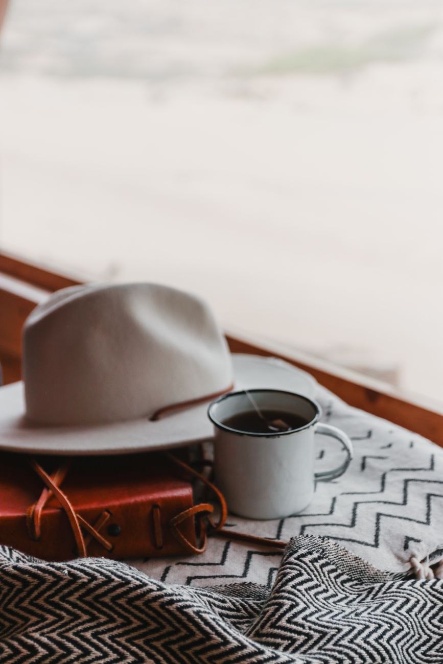 Notebook and hot tea on wooden table with alpine view