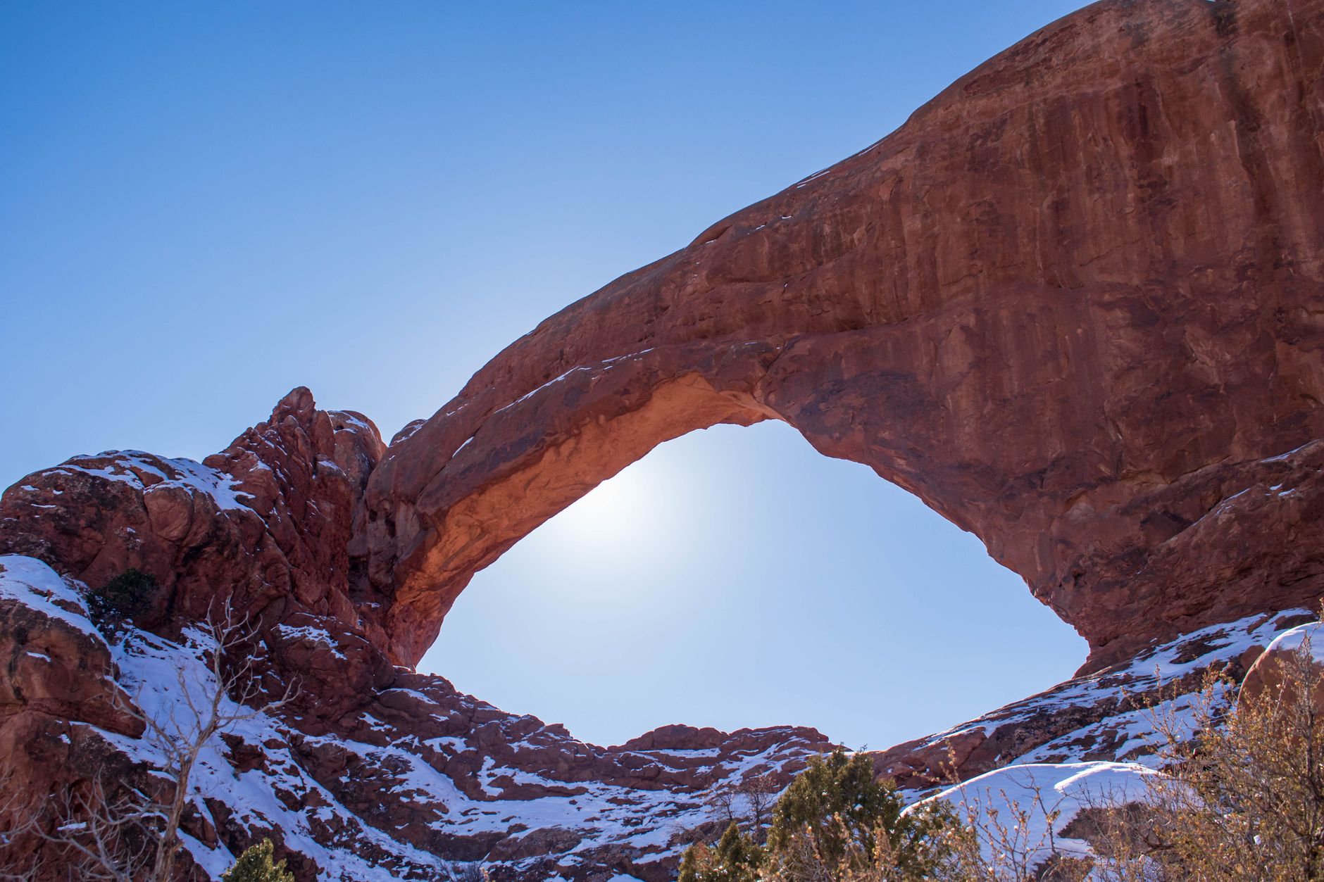 Towering red sandstone cliffs under stark desert sky