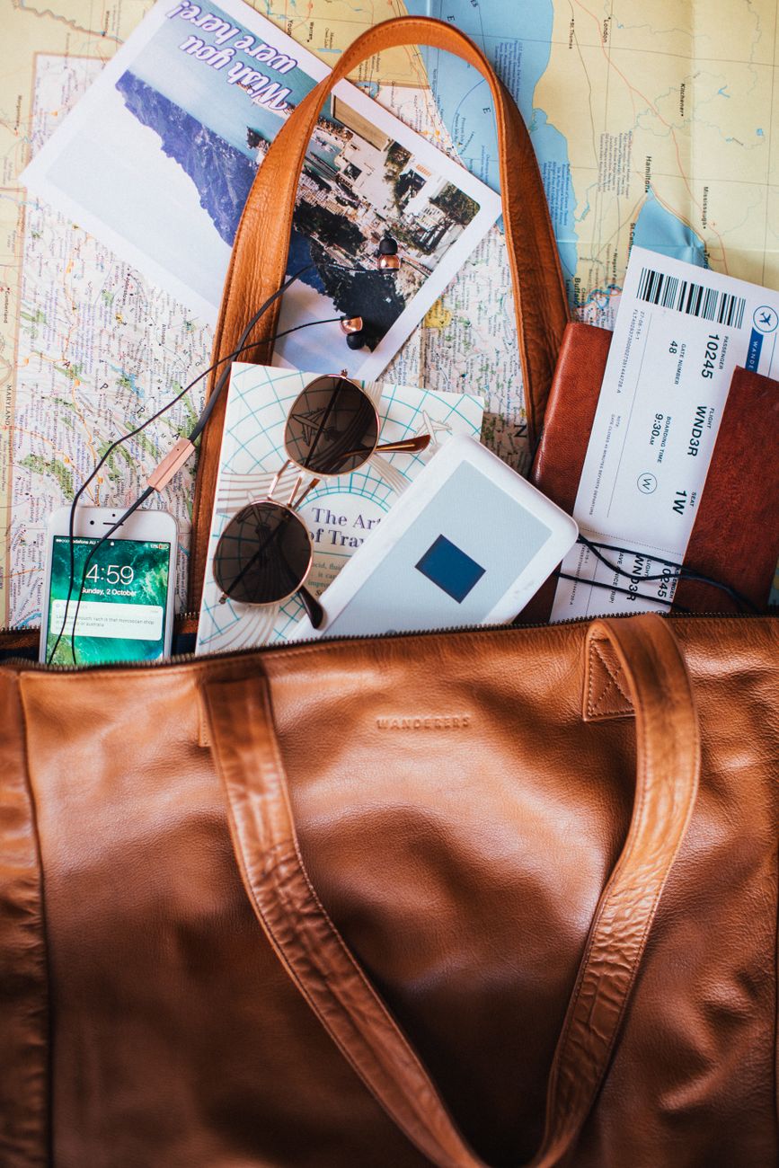 Open map and leather luggage in wooden hotel room